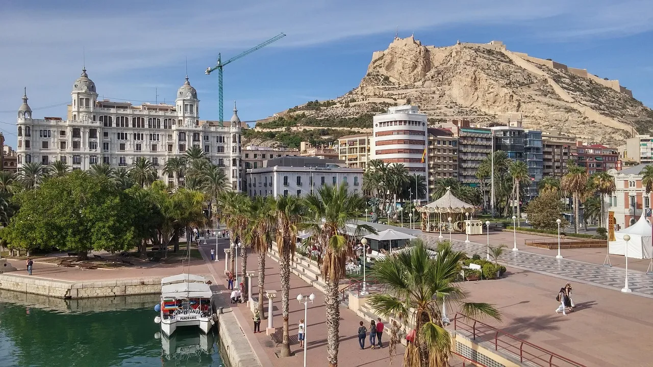 El paseo marítimo bordeado de palmeras de Alicante, bajo el monte del castillo de Santa Bárbara