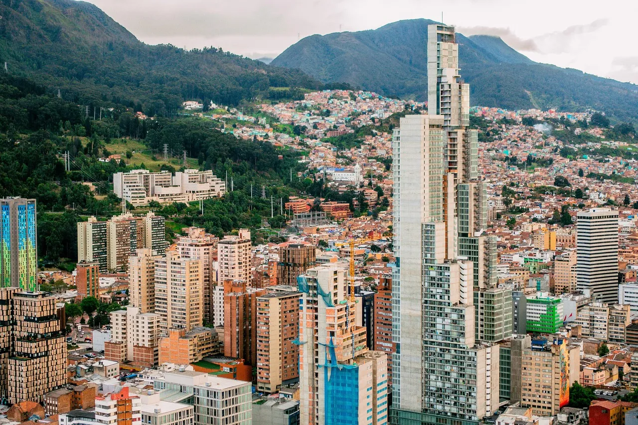 Apartment towers on the slopes below green mountains in Bogotá