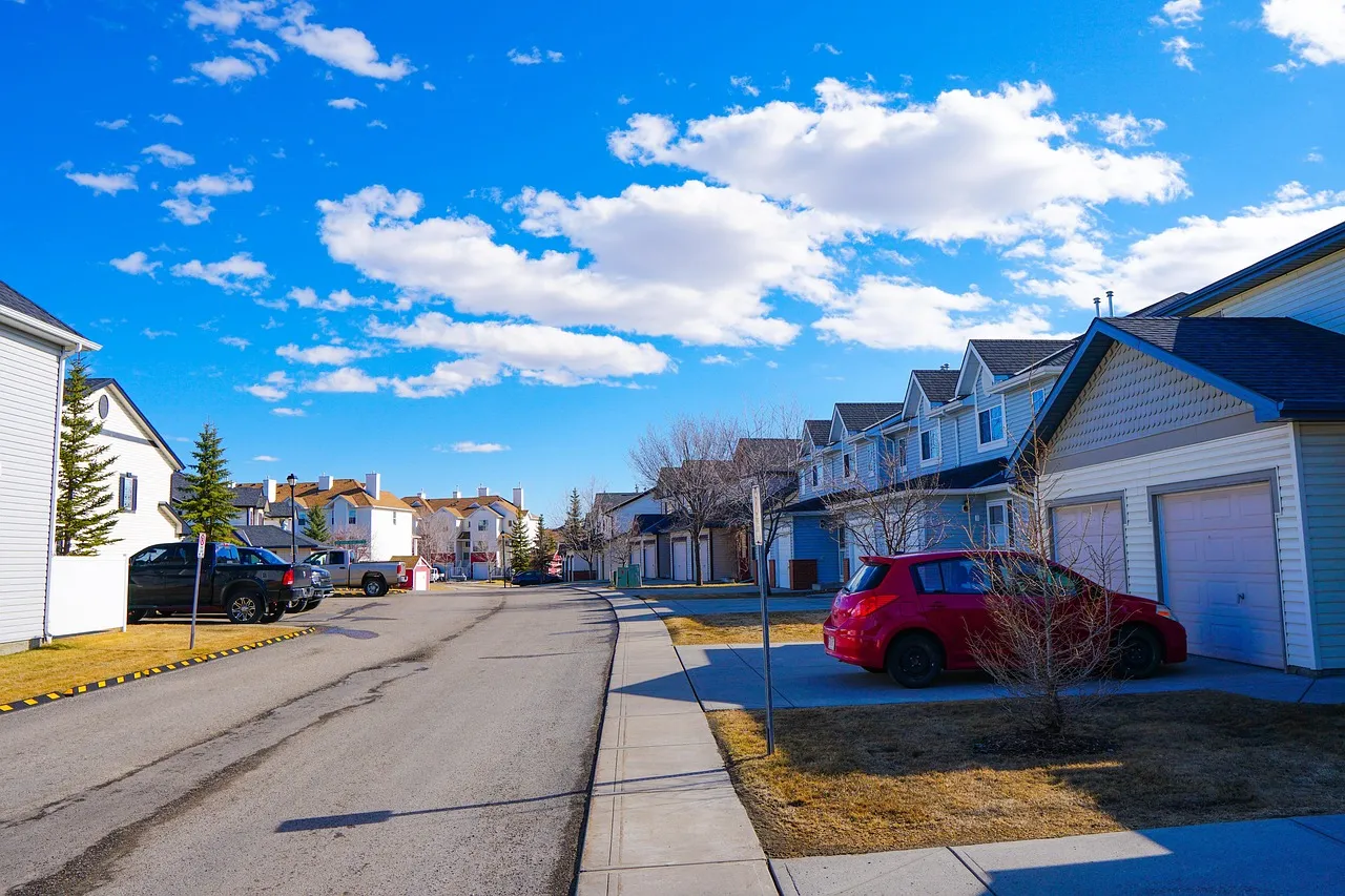 Una calle residencial de las afueras con casas adosadas y garajes