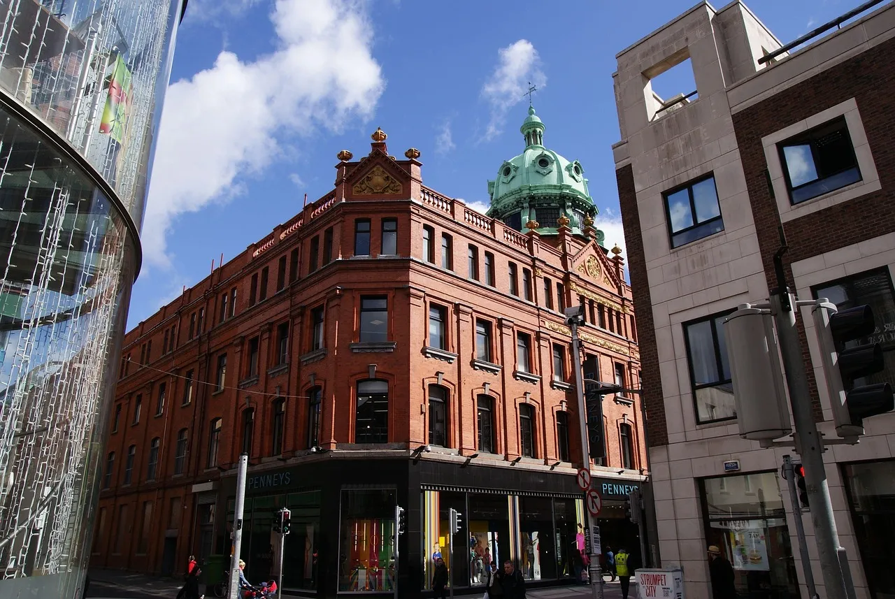 A red-brick corner building with a copper dome in central Dublin