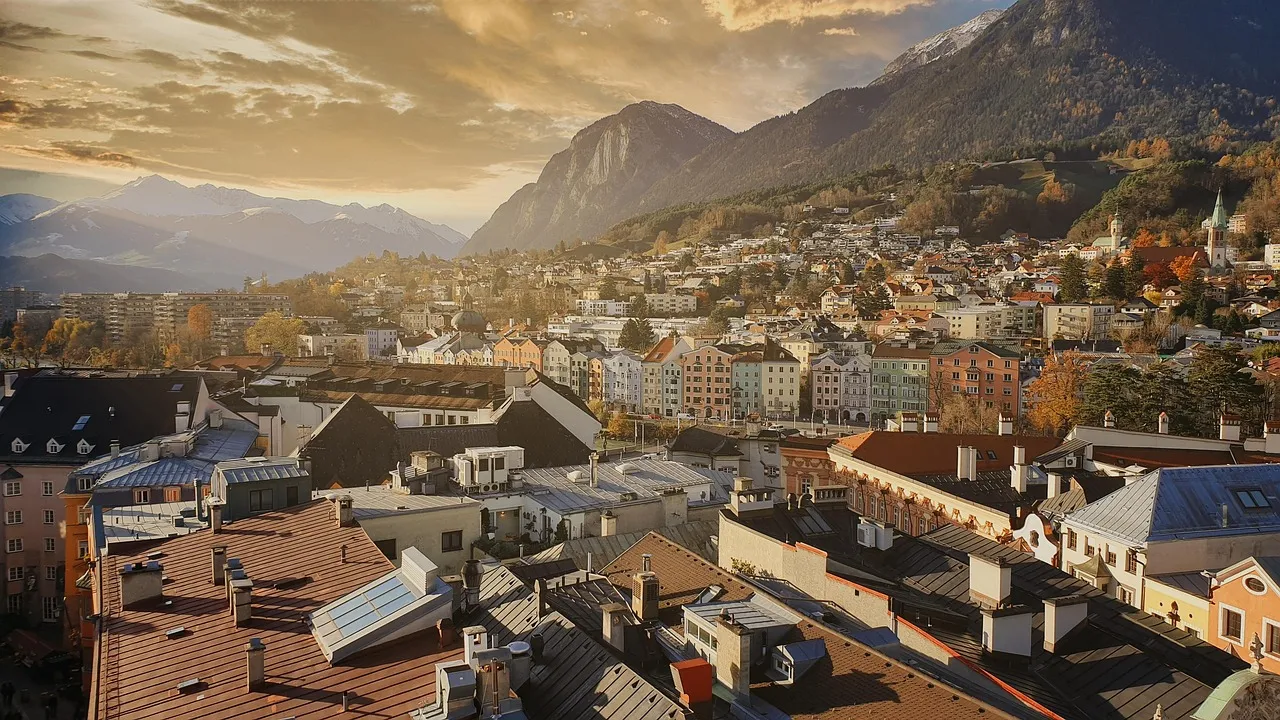 Dächer bei Sonnenuntergang, dahinter die Berge