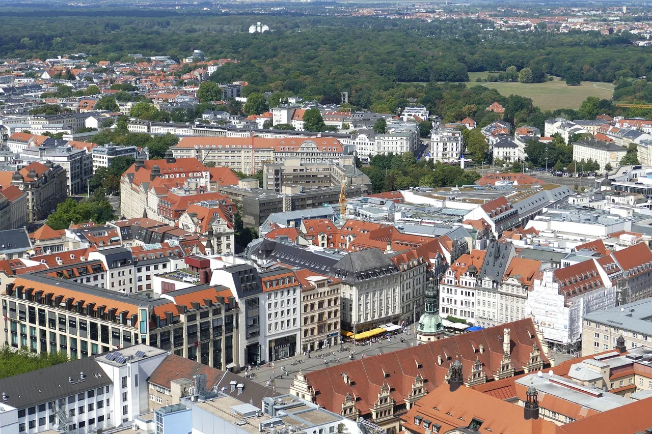 Die Dächer der Innenstadt, dahinter grüne Vororte
