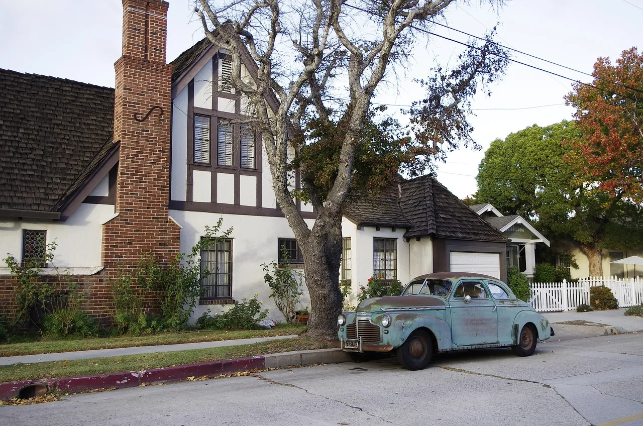 A house on a residential street with a vintage car outside