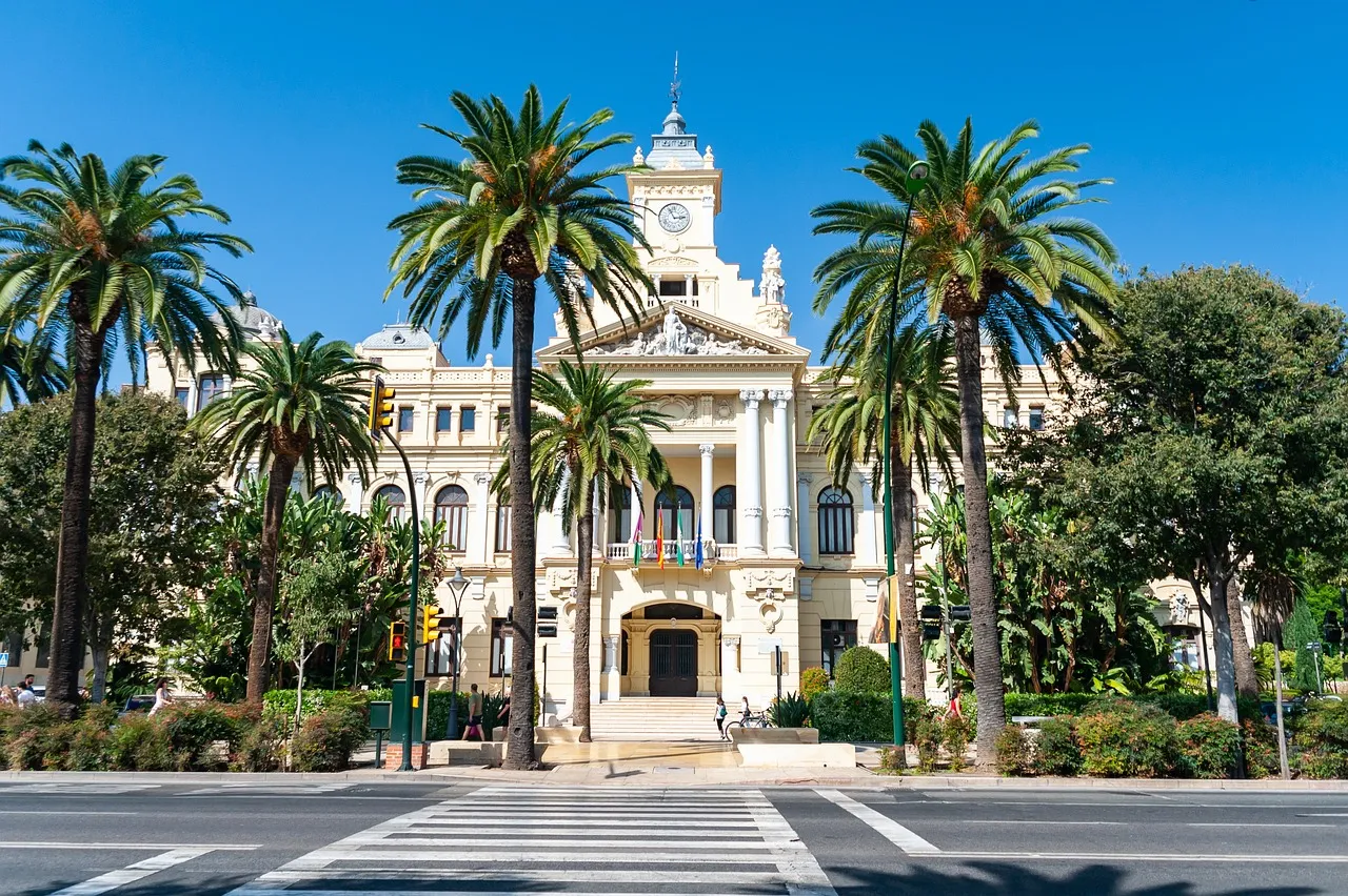 Das Rathaus von Málaga hinter den Palmen des Paseo del Parque