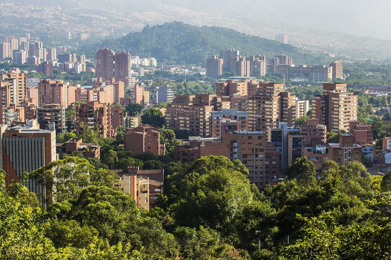 Apartment towers among trees in Medellín, with hills behind