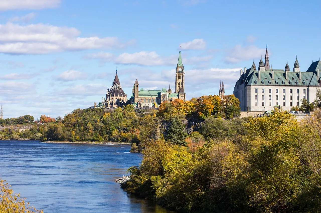 La colina del Parlamento de Ottawa sobre el río en otoño