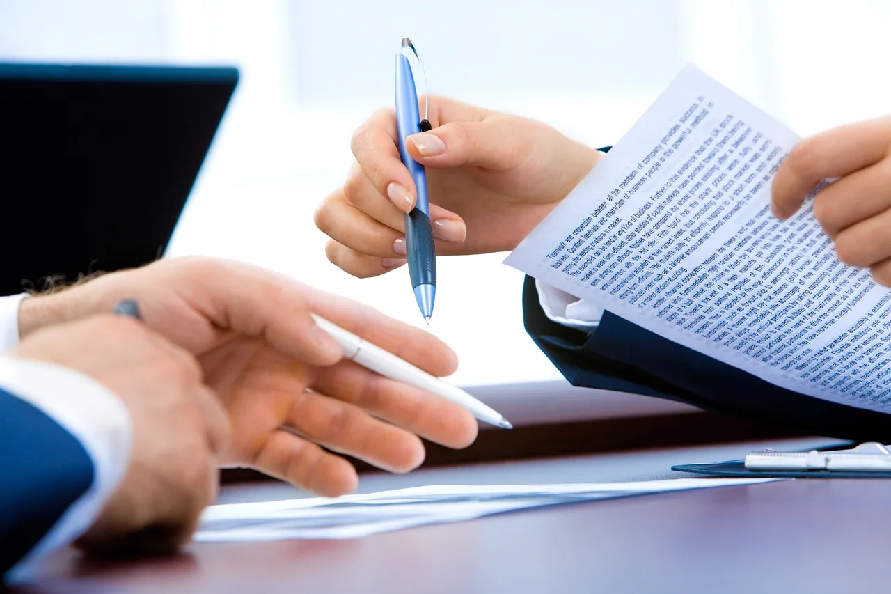 Dos personas revisando documentos en un escritorio