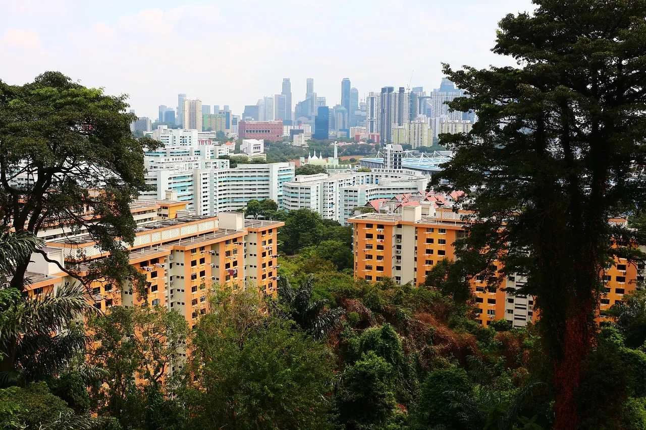 Bloques de vivienda pública entre árboles con el horizonte de la ciudad al fondo