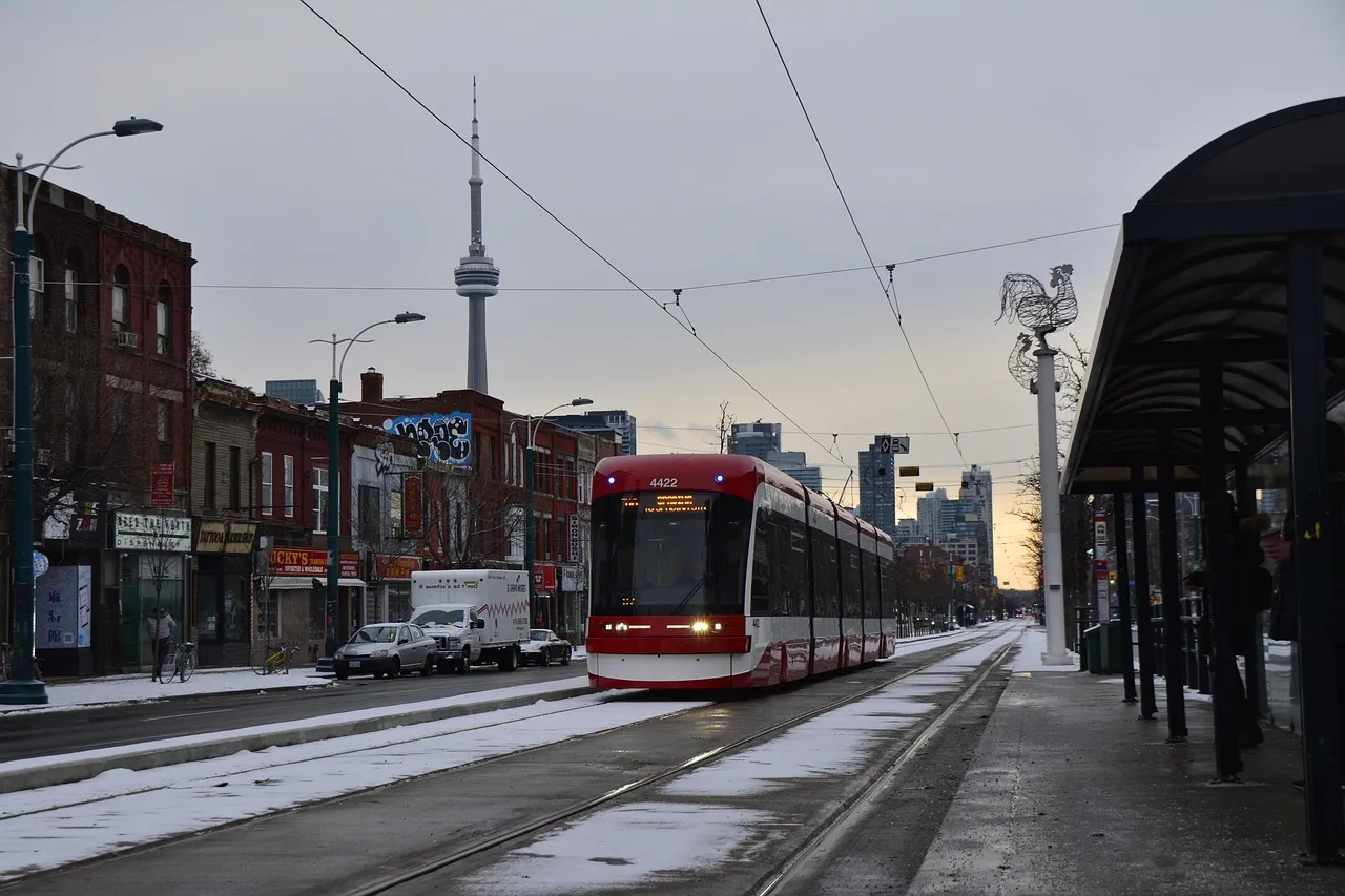 A streetcar on a Toronto street with the CN Tower behind